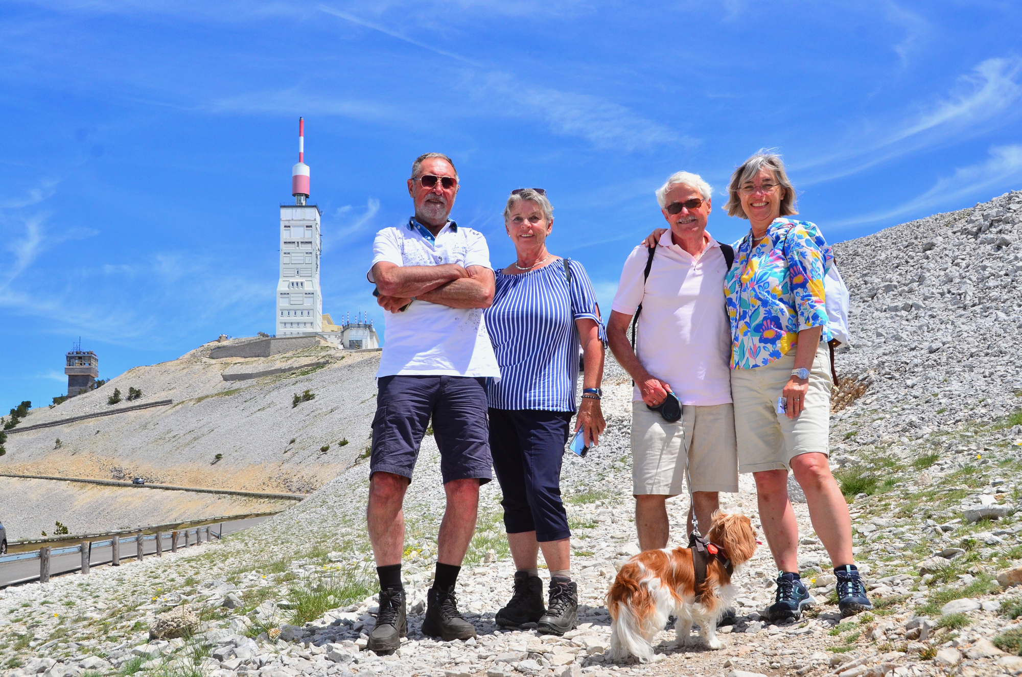 Quatre personnes posent ensemble avec leur chien.